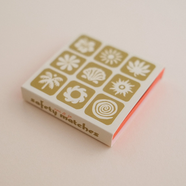 Matchbox with geometric tropical designs on a light pink background