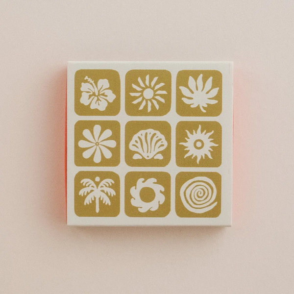 Box of matches with various tropical patterns on a light pink background