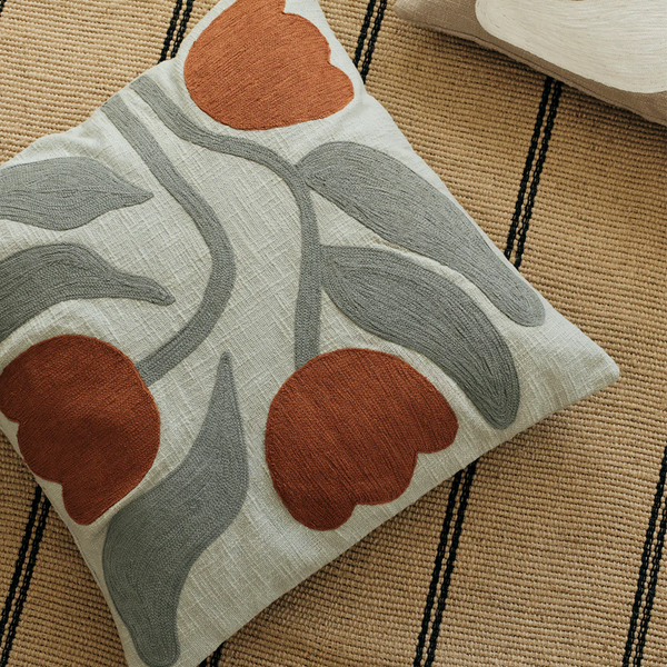 Decorative pillow with leaf pattern on a textured surface