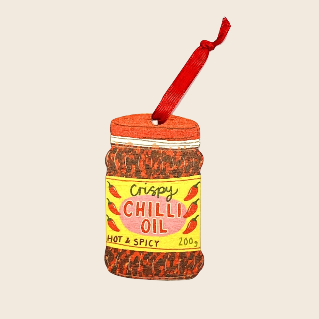 Decorative ornament shaped like a jar of 'Crispy Chilli Oil' on a beige background
