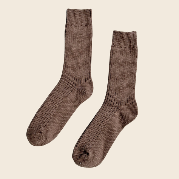 A pair of ribbed crew socks in a heathered brown color, displayed against a solid light beige background.