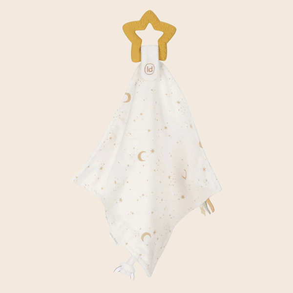 A white muslin baby security blanket with a gold crescent moon and star pattern, attached to a gold star-shaped teething ring by a white strap. 