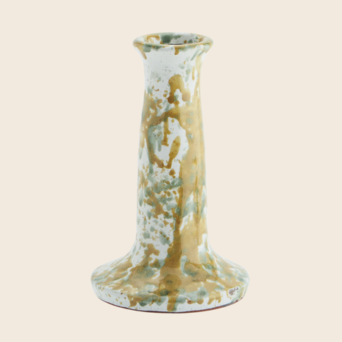 Decorative ceramic candle holder with gold and green marbled pattern on a beige background