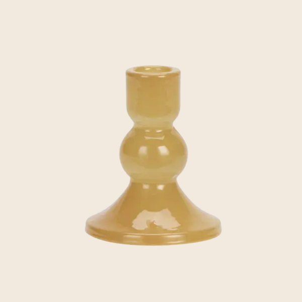 A small glossy ceramic candlestick holder with a bulbous middle section and a flared base, shown on a plain light beige background.