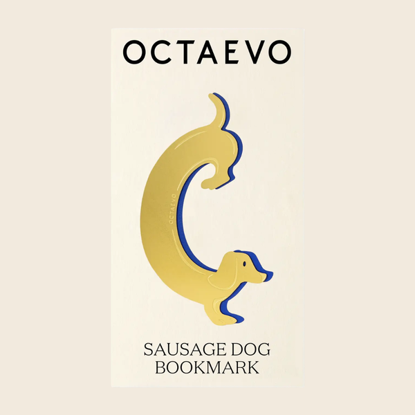 A gold sausage dog shaped bookmark, displayed on a cream coloured card with the brand name 'OCTAEVO' at the top and the text 'SAUSAGE DOG BOOKMARK' at the bottom.