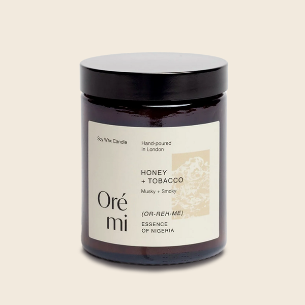Candle jar labeled 'Honey + Tobacco' by Ore mi on a beige background
