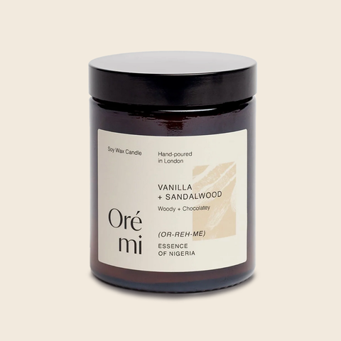 Scented candle labeled 'Vanilla + Sandalwood' by Ore mi on a beige background