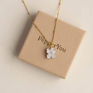 Necklace with a white flower pendant on a 'PepperYou' branded box.