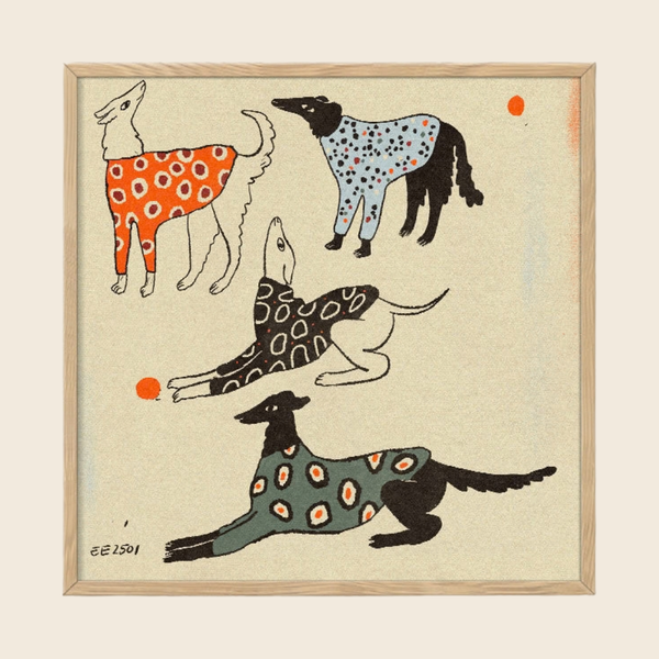 A framed art print featuring four stylized dogs in different poses, each wearing a patterned sweater in orange, light blue, black, and green, on a textured cream background with a light wood frame.