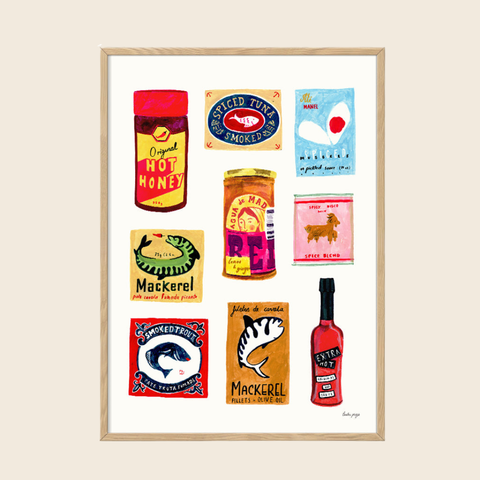 Framed artwork with colorful labels and product illustrations on a beige wall.