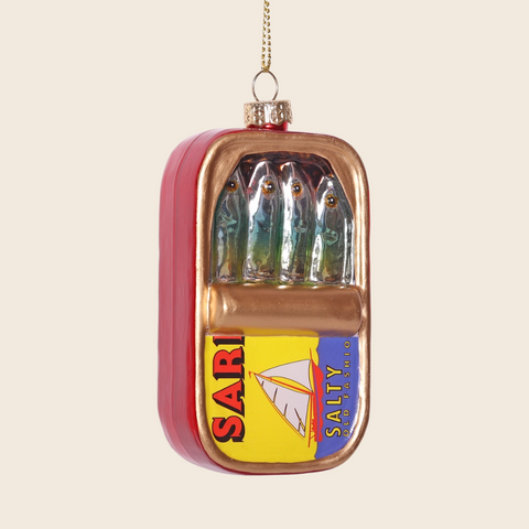 Decorative ornament shaped like a can of sardines on a beige background.