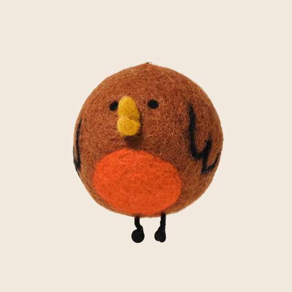 A cute, round felt bird ornament in brown, featuring a bright orange belly, yellow beak, and small black feet and facial details, set against a solid light beige background.